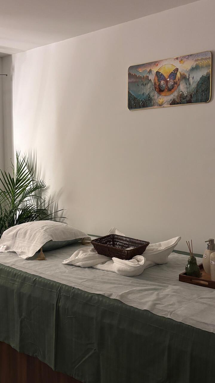 A treatment room set and waiting, a palm beside the bed